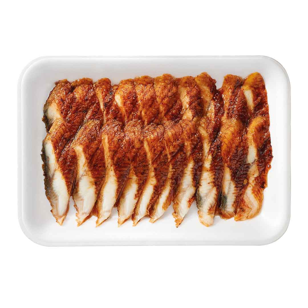 Nahaufnahme von fein aufgereihten, marinierten Fischfilets in Scheiben auf einer weißen Servierplatte