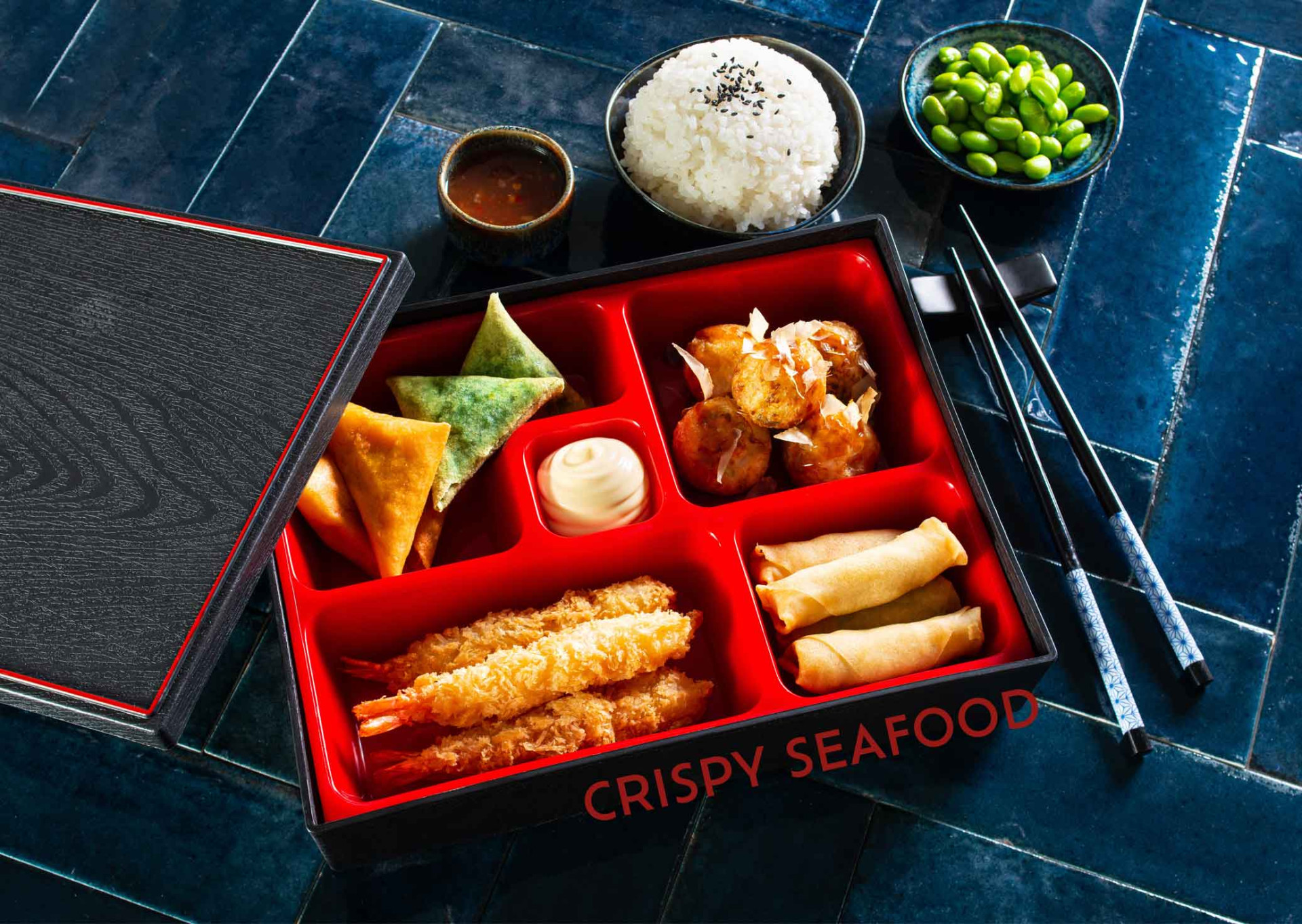 Japanische Bento-Box mit Crispy Seafood, Reis und Edamame